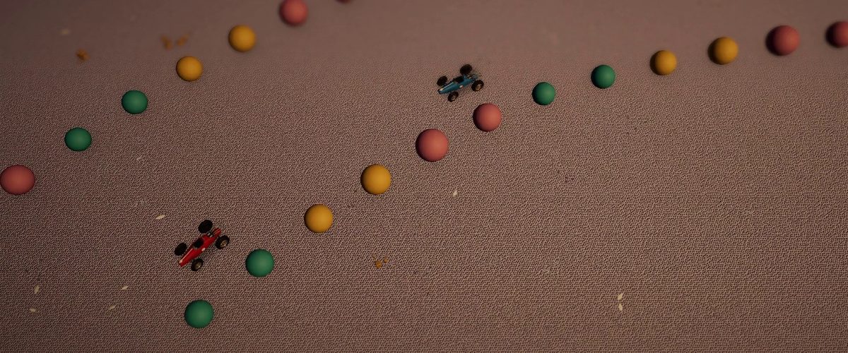 Dos pequeños coches de carreras sobre una pista de caramelos en el suelo del dormitorio