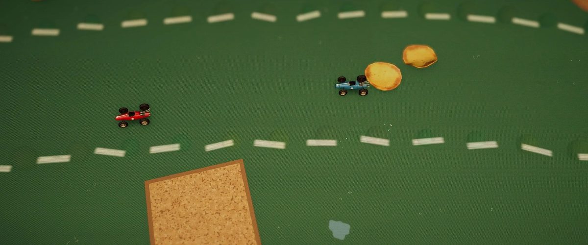 Dos pequeños coches de carreras siguen una línea discontinua sobre una mesa de juego verde