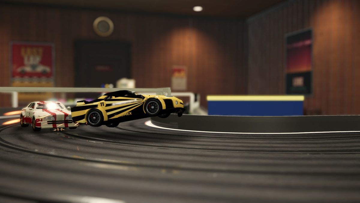 A yellow and black car leaves the slot on a bend